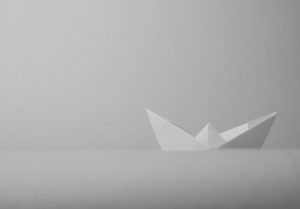 A greyscale image of a paper boat.