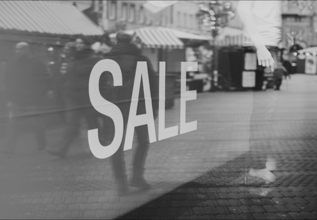 sale sign in shop window display black and white